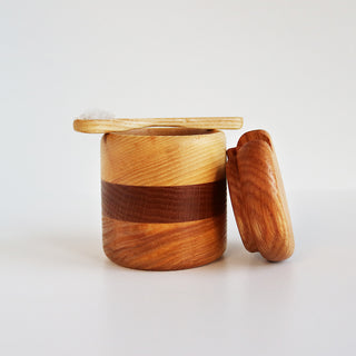 Main de sel en chêne et frêne avec cuillère en bois posée sur le pot