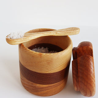 Main de sel en chêne et frêne remplie de sel avec cuillère en bois.